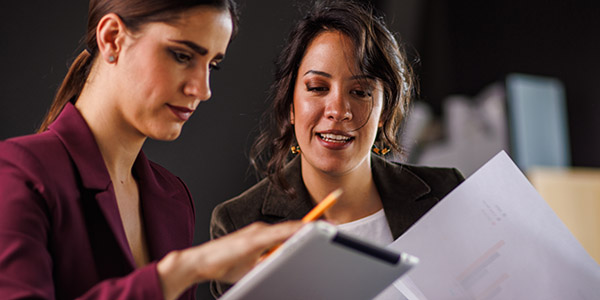 Two businesswomen having a project meeting, reviewing data and discussing strategies